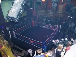 Black canvas boxing ring cover with red white and blue rope covers and corner pads covers.