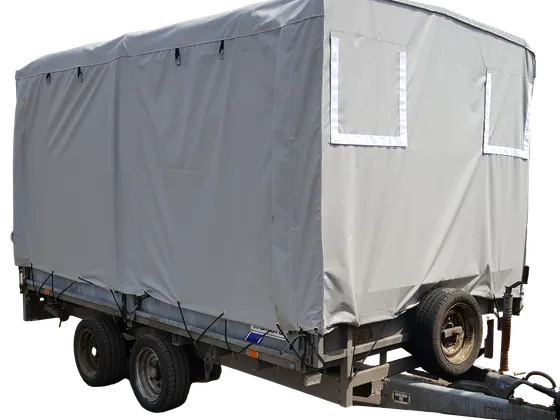 Large grey trailer cover with velcro flaps and hoops, secured to the trailer with bungee